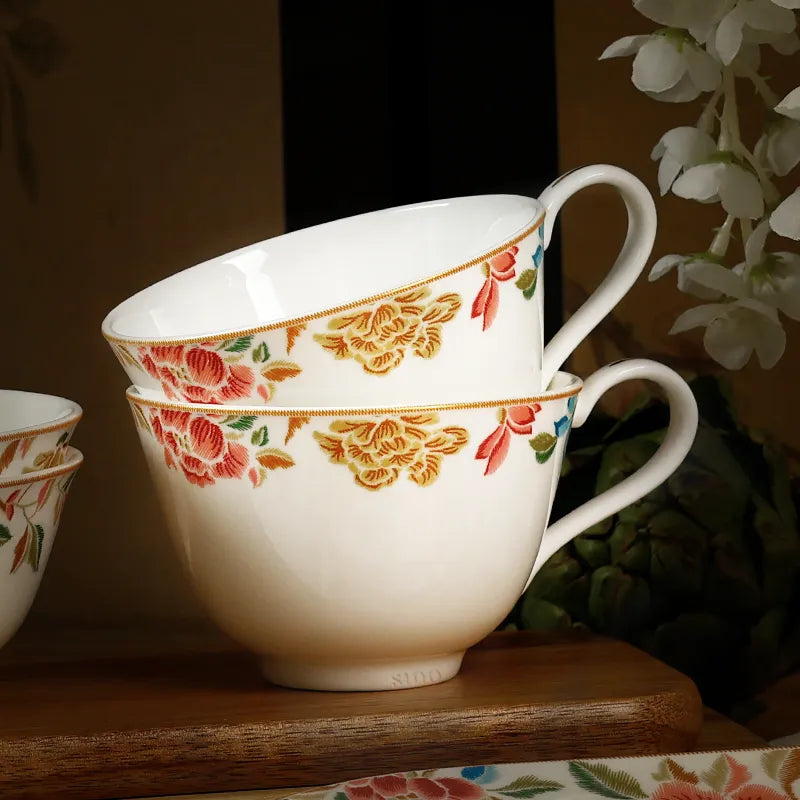 Two Chinoiserie tea cups stacked together.