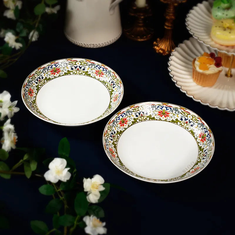 Two angled Chinoiserie plates with afternoon tea accessories on blue cloth.