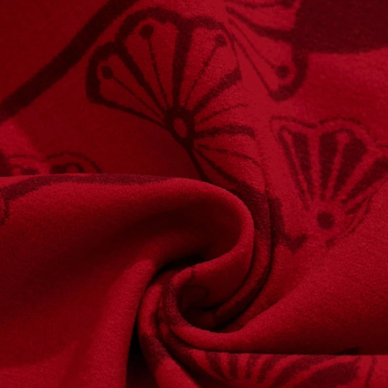 Model wearing the red Year of the Goat mulberry silk scarf against a deep red background.
