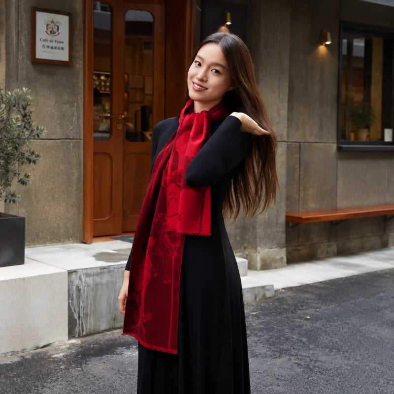 Woman styling a red Chinese New Year silk scarf with a black dress outside a café.