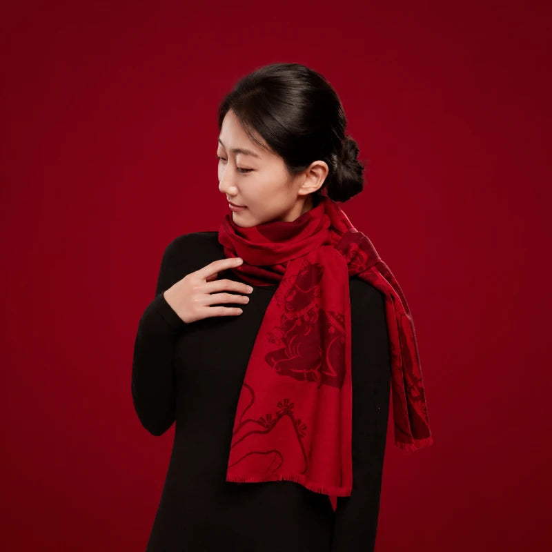 Red Year of the Goat silk scarf displayed with coordinating gift packaging and festive Chinese New Year decorations.