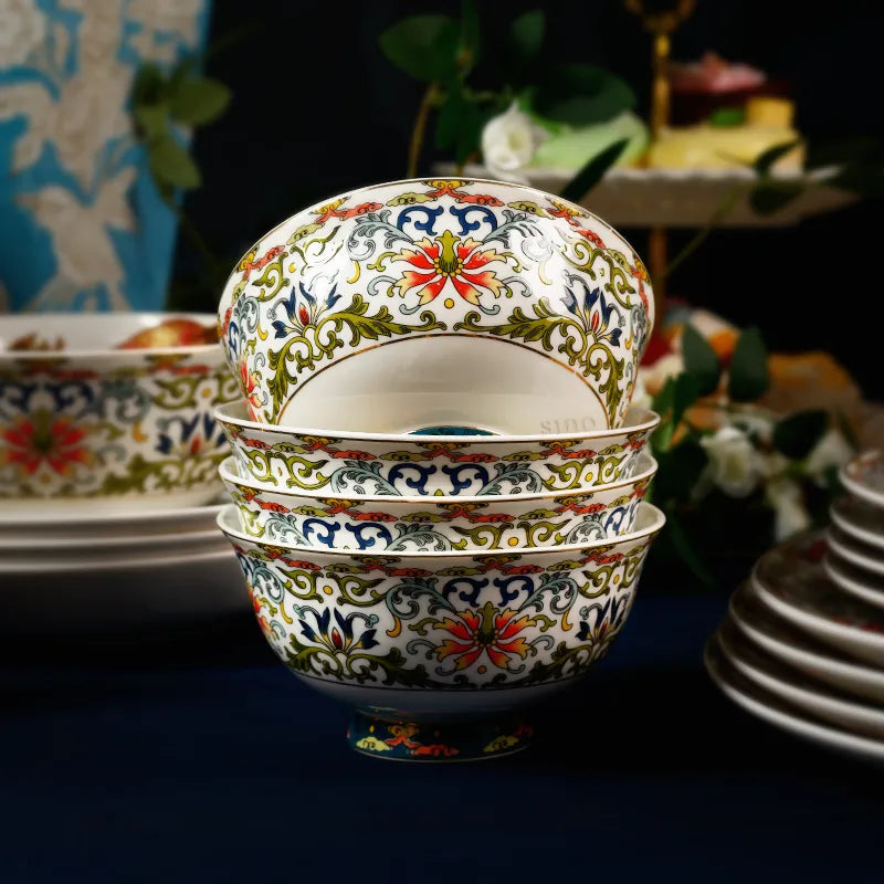 Four stacked bowls with tilted top bowl showing enamel bottom and matching tableware.