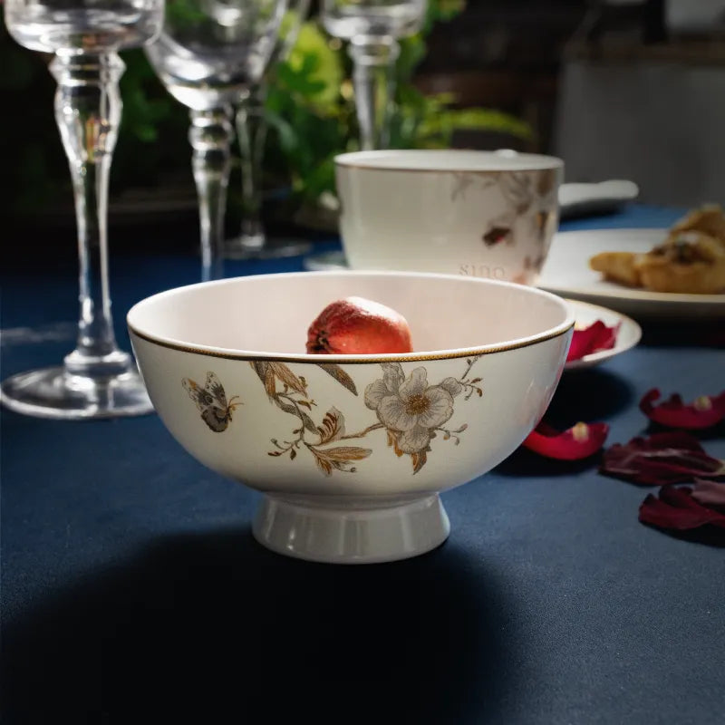 Chinoiserie Footed Bowl holding fruit with rose accents and wine glass.