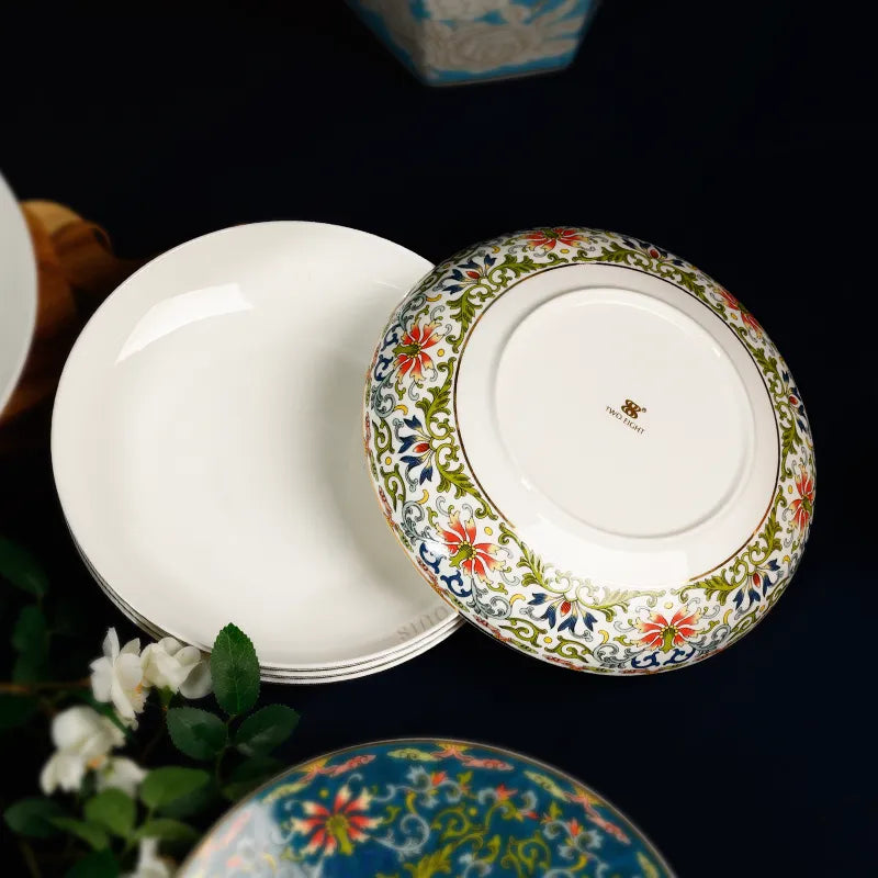 Stacked Chinoiserie plates with inverted piece showing enamel design on blue cloth.