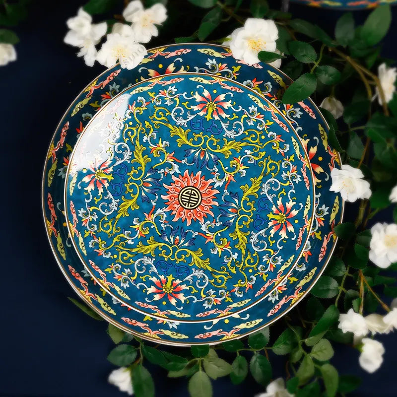 9’’ Chinoiserie Luxury Enamel Dinner Plate standing to showcase hand-painted details with flowers on blue tablecloth.