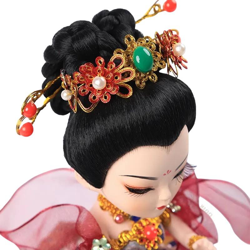 Detail of 9-inch Dunhuang doll's headdress with golden accents, red beads, and green gem.