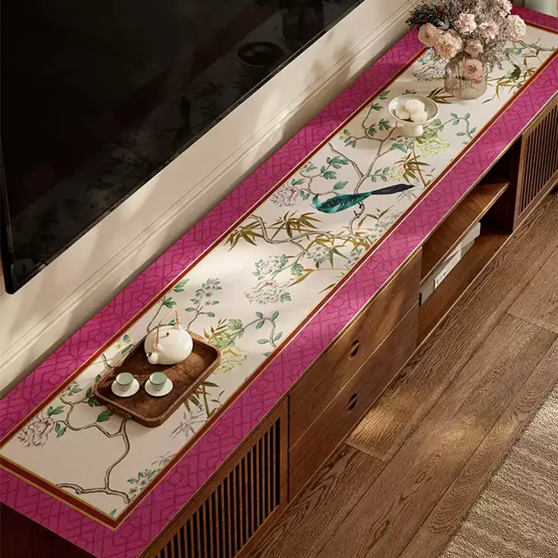 Chinoiserie floral bird table mat with teapot and vase arrangement on low-profile TV console.
