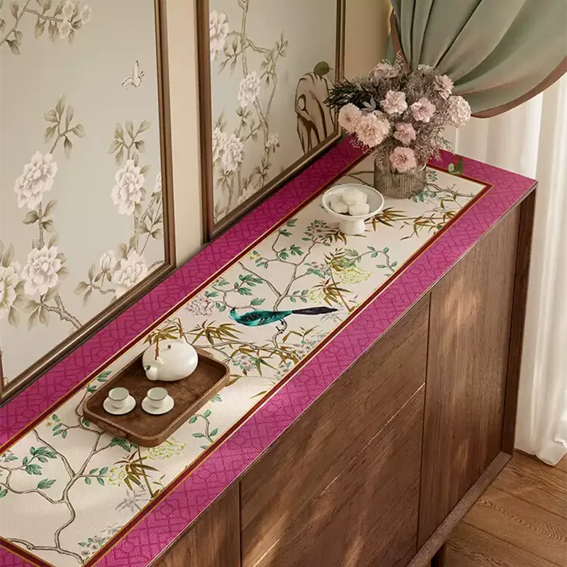 Vintage pink floral bird TV table mat styled with teapot, teacups, and vase of fresh flowers on rectangular cabinet.
