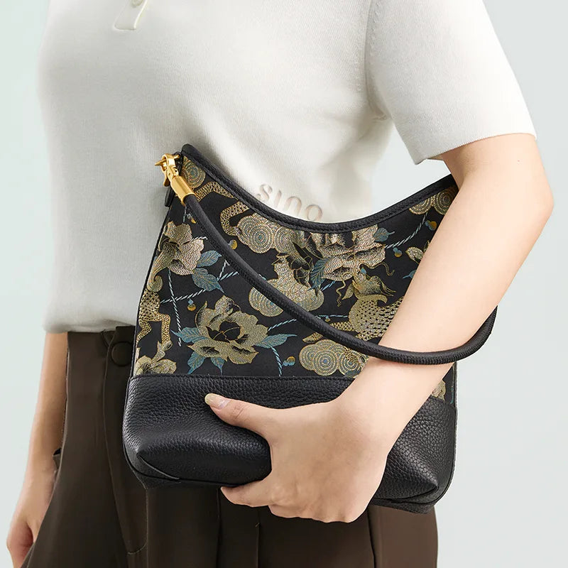 Model holding the black Song Brocade Qilin Peony leather shoulder bag with a modern neutral outfit.