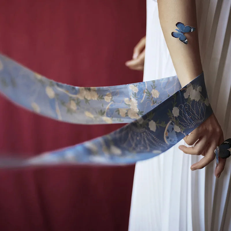 Blue Blooming Peony Mulberry Silk Twilly styled around the wrist, showing its flowing floral pattern and versatile skinny scarf design.