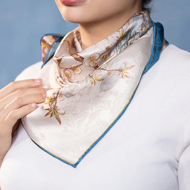 Blue side of the Luxury Nanjing Brocade Bloom silk square scarf worn around the neck with delicate floral and palace details.