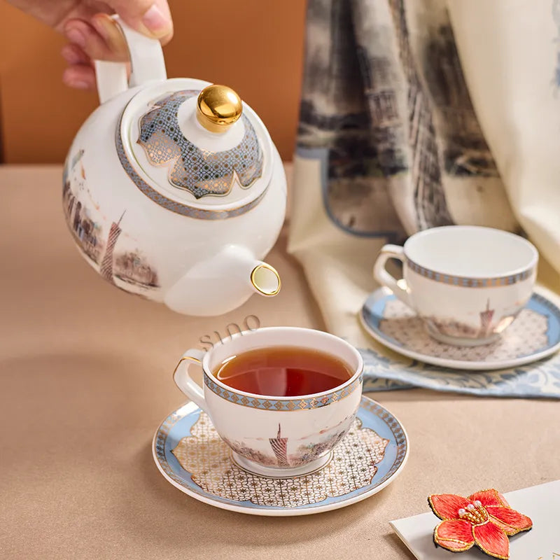 Bone china teapot pouring tea into cup in Pearl River Skyline design.