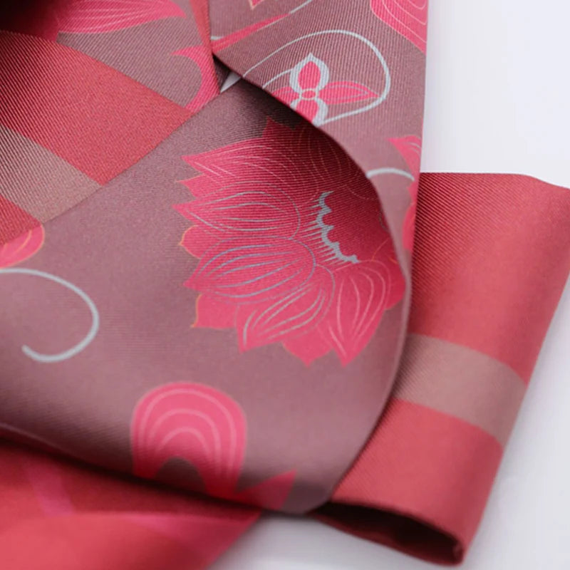 Close-up of the Chinese Dunhuang Motif Print Mulberry Silk Twilly 160x7.3 cm highlighting pink floral motifs and elegant silk finish.