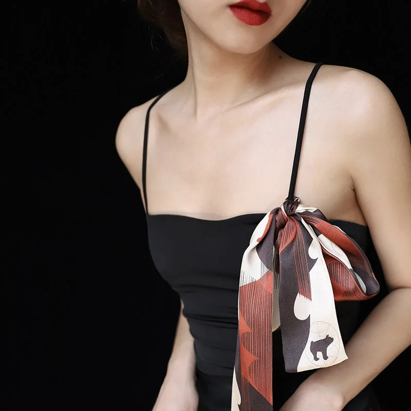 Chinese Han Dynasty Painted Pottery Motif mulberry silk twilly scarf styled as a decorative bow on a black dress.