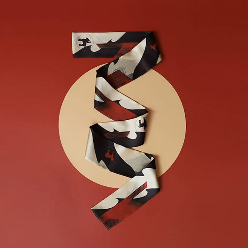 Flat lay of Chinese Han Dynasty Painted Pottery Motif mulberry silk twilly scarf in cream, black and rust tones.