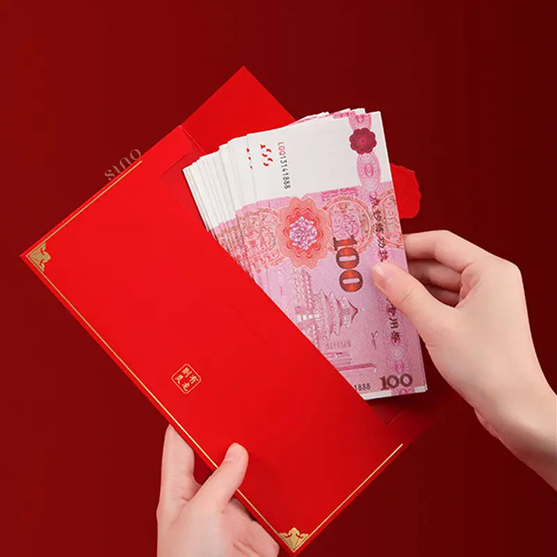 Traditional Chinese red money envelope being filled with Chinese banknotes, illustrating the custom of giving lucky money during Chinese New Year and other celebrations.