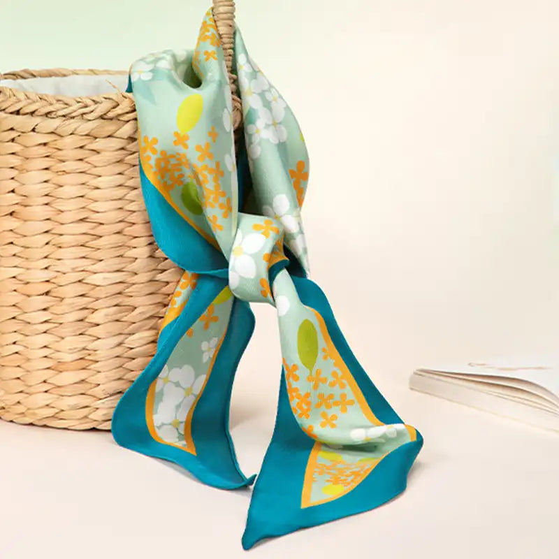 Chinese Verdant Garden Print Mulberry Silk Diamond Scarf 120x32 cm tied on a woven handbag as a chic accessory accent.