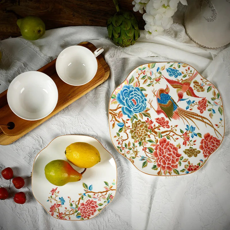 Top view of 4-piece Chinoiserie bone china set: square plates, bowl, teacup with floral & bird design.
