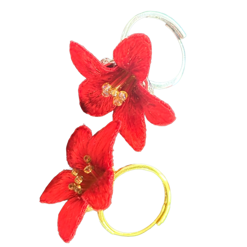 Close-up of handmade red kapok flower earrings crafted with traditional Cantonese embroidery.