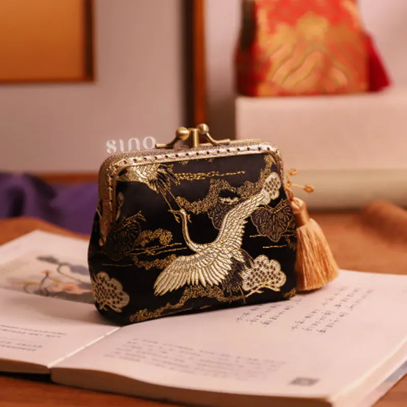 Lifestyle display of the Chinoiserie Hand-Finished Silk Mini Coin Purse Wallet - Black Crane, a hand-finished silk kiss lock coin purse with crane pattern styled in an elegant Chinese-inspired setting.