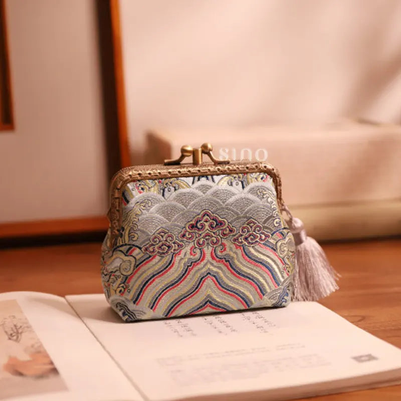 Lifestyle display of the Chinoiserie Hand-Finished Silk Mini Coin Purse Wallet - Silver Sea Cliff, a hand-finished silk kiss lock coin purse styled in an elegant Chinese-inspired setting.