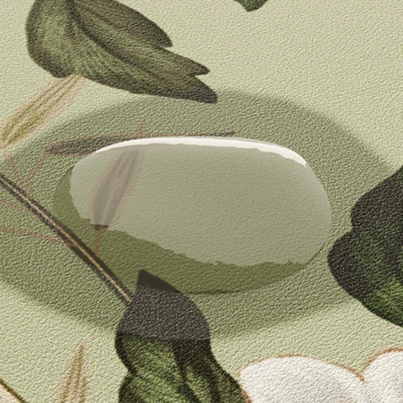 Waterproof detail of chinoiserie jade green leather placemat as water beads on surface.