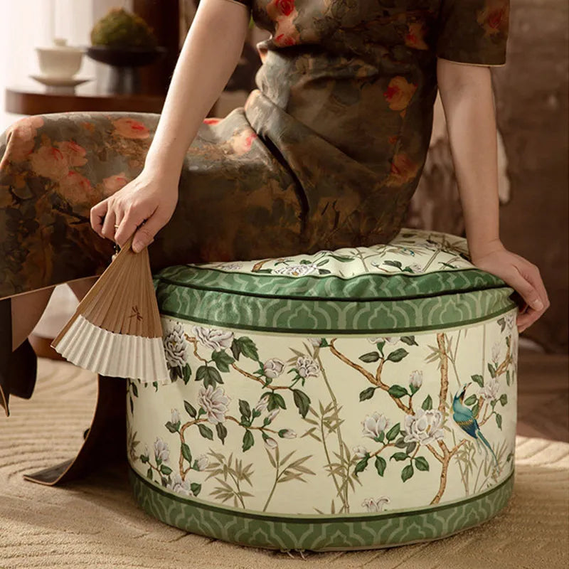Model sitting sideways on the chinoiserie jade green couch cushion pouf.