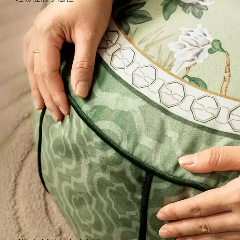 Model hugging the chinoiserie jade green rest floor pouf to show its versatile use as a floor cushion or footrest.