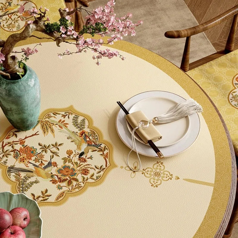 Close-up of Autumn Splendor round leather dining table mat with delicate floral and bird medallion in warm golden tones.