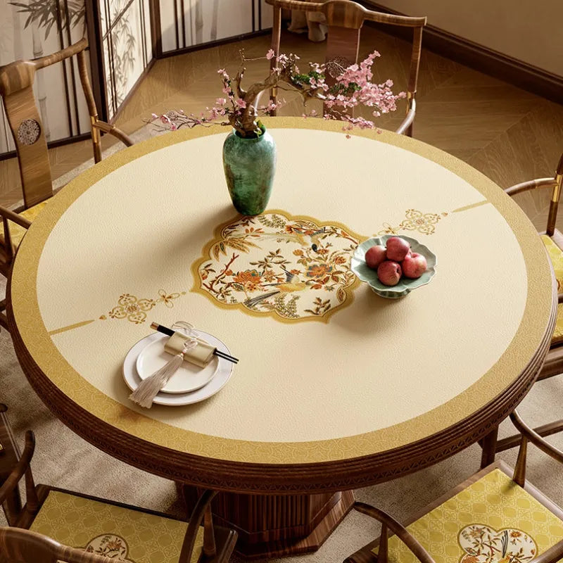Ivory and golden Autumn Splendor round leather table mat with elegant Chinoiserie floral and bird medallion.