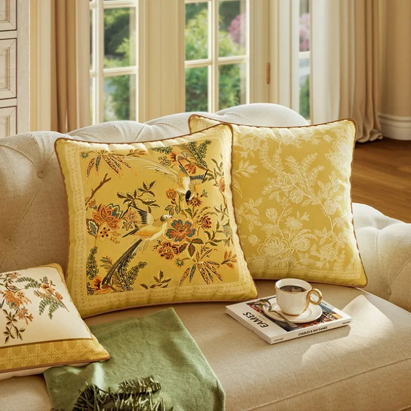 Pair of Autumn Splendor yellow decorative throw pillows with floral and bird designs styled on a sofa for a cozy fall home decor refresh.