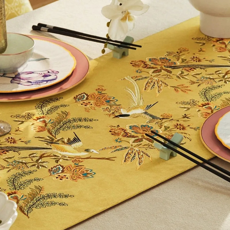 Close-up detail of a yellow Chinoiserie table runner with floral bird pattern, ideal for fall table styling and decorative dining room accents.