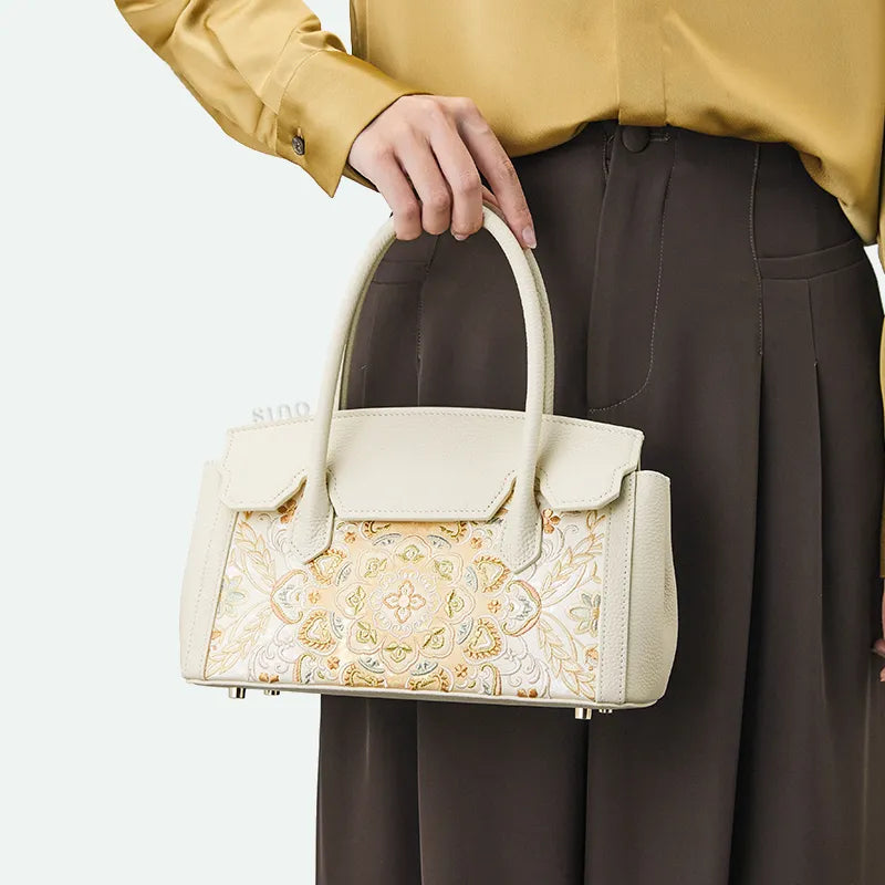 Model handheld carrying chinoiserie luxury lotus motif leather handbag.