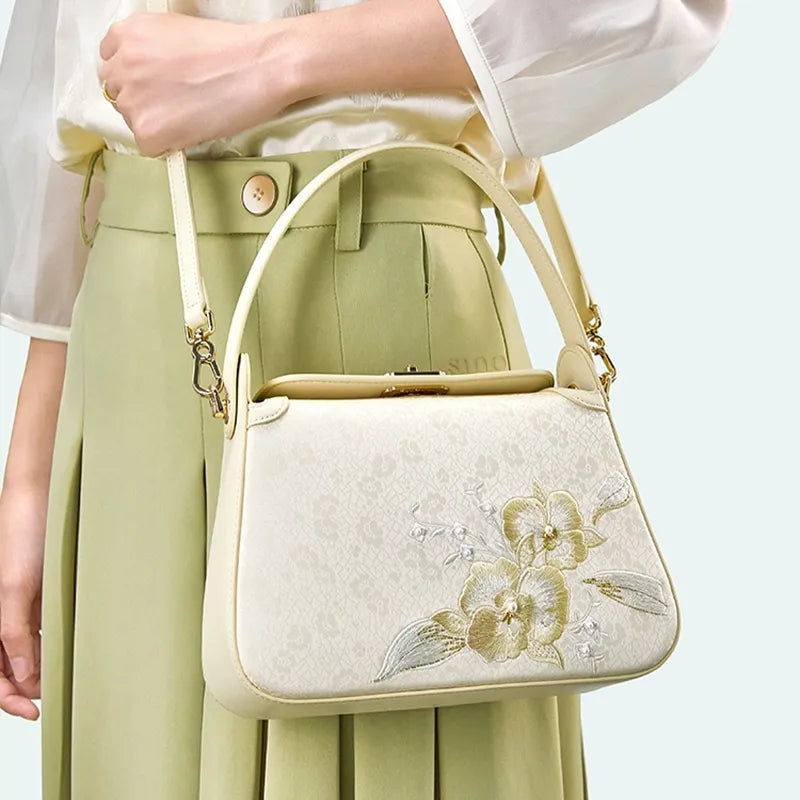Model standing sideways with Chinoiserie Luxury Orchid Butterfly Embroidered Silk Handbag crossbody.