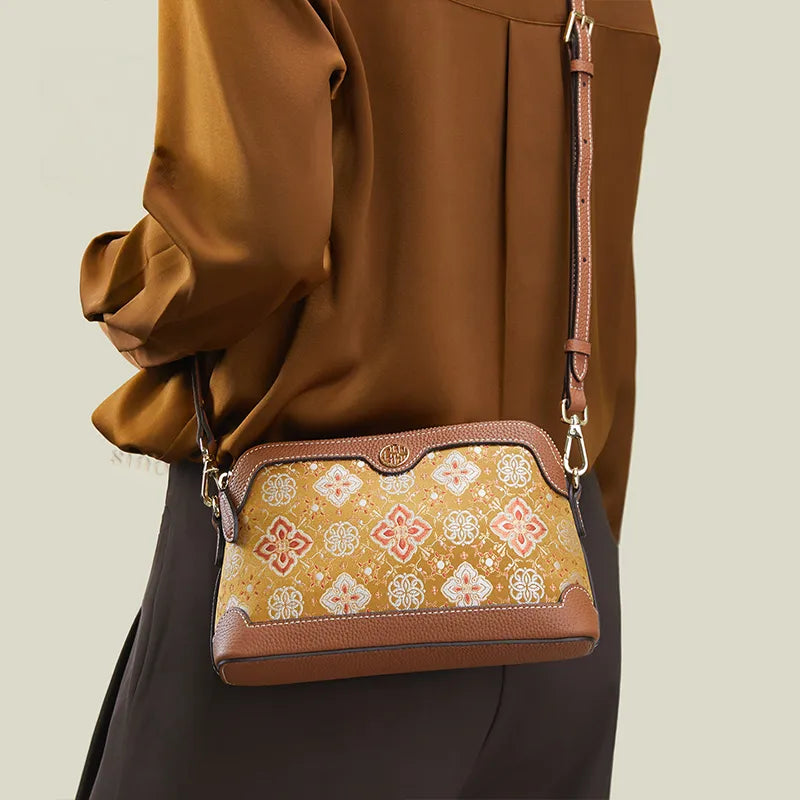 Model back view wearing the Persimmon Calyx Motif crossbody clutch bag with strap.