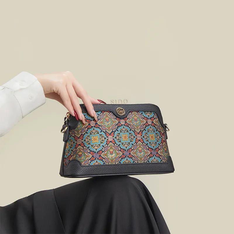 Model seated with the Chinoiserie Curled Lotus clutch purse resting on the knees.