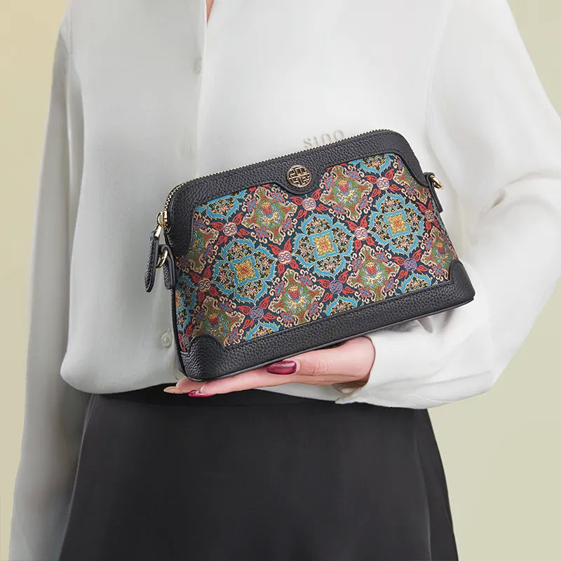 Model standing sideways holding the Chinoiserie Song Brocade Curled Lotus clutch bag by hand.
