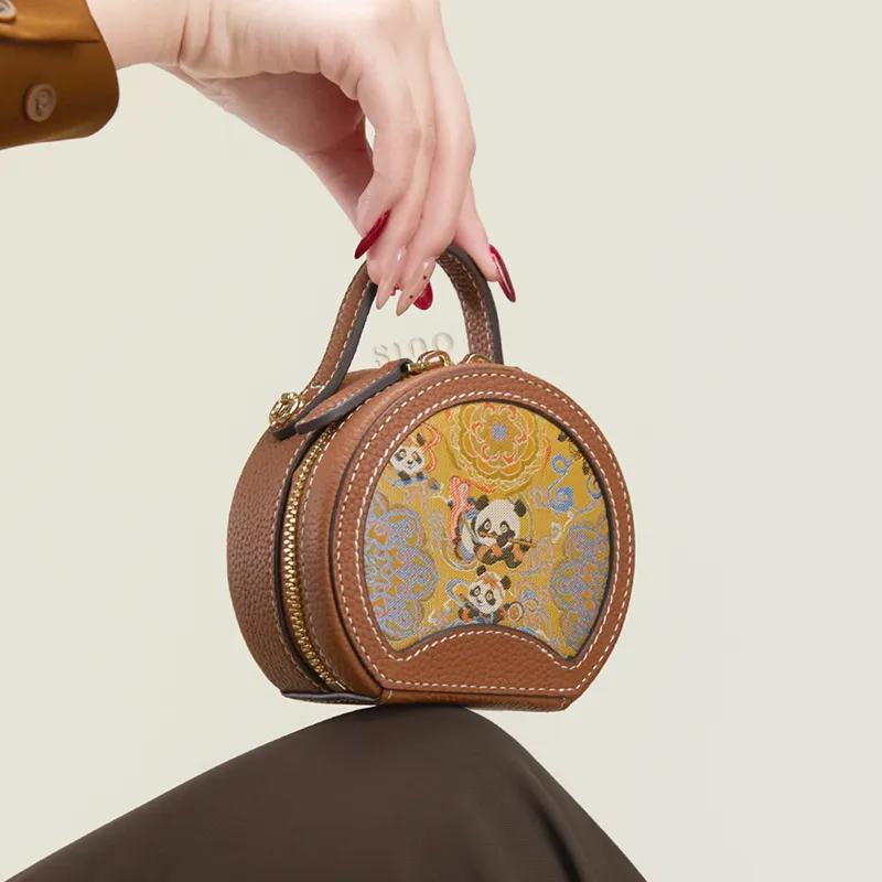 Model seated with the Joyful Panda mini round handbag placed on the knees.