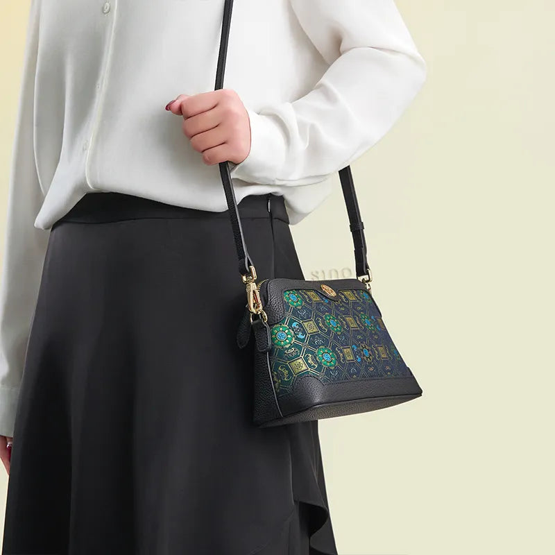 Model standing sideways wearing the Lotus & Bat Motif clutch bag as a shoulder bag.