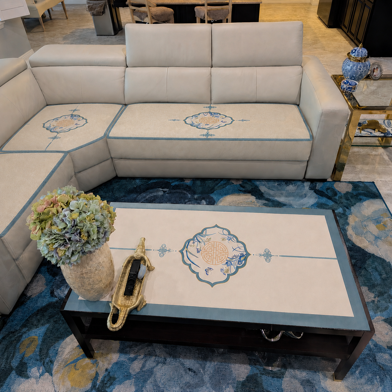 Chinoiserie Luxury Summer Blue Quilted Couch Cover Sofa Protector displayed on a white sectional sofa with matching blue-bordered cushions and traditional Chinese longevity motifs.