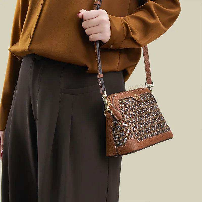 Model standing sideways wearing the Osmanthus Motif clutch bag as a shoulder bag.