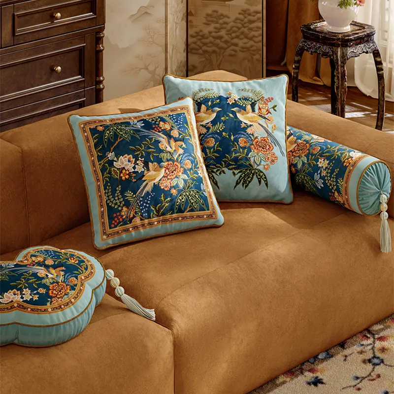 Luxury chinoiserie watercolor pillows on sofa, angled view.