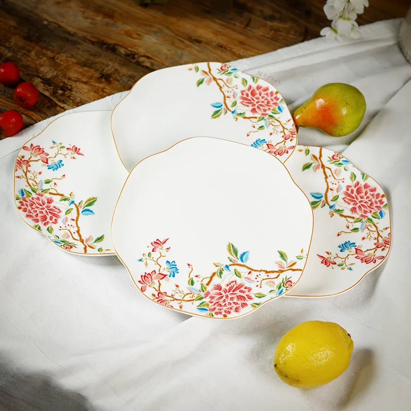 Angled view of four porcelain plates with pears, showcasing depth and floral design.