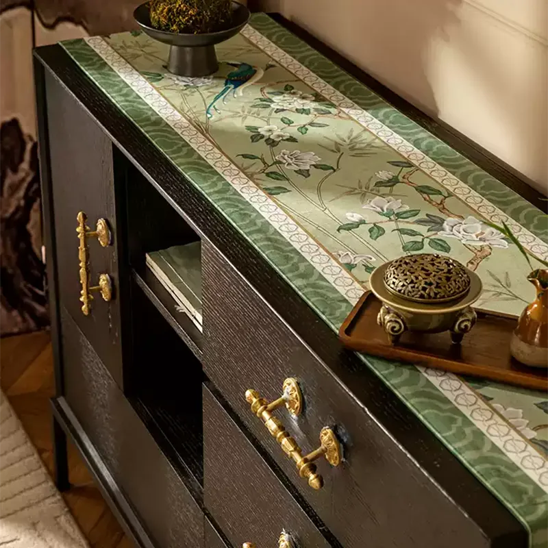 Jade green chinoiserie long table runner with tassel fringe on an entryway console table with a Chinese incense burner.
