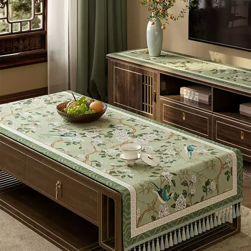 Angled view of chinoiserie vintage jade green tablecloth styled on a living room coffee table.