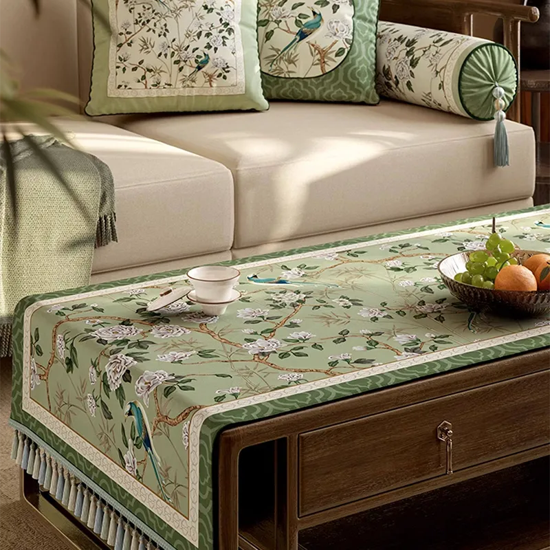 Front view of jade green chinoiserie tablecloth on coffee table with sofa in background.