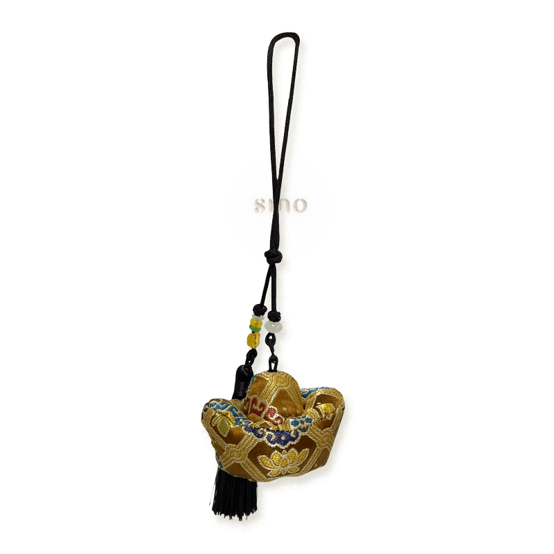 Golden Yuanbao bag charm crafted from Yunjin brocade with a dark hanging cord, decorative beads, and a long tassel.