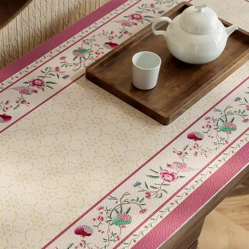 Coral pink leather cabinet mat with floral border detail.