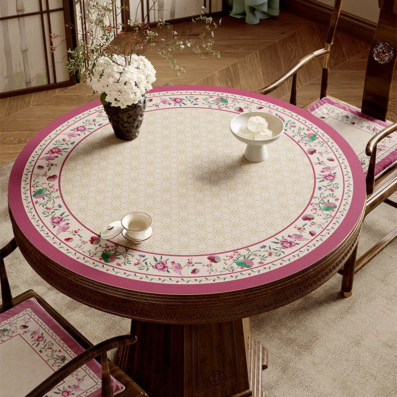 Coral pink round leather table mat with Chinoiserie floral border.