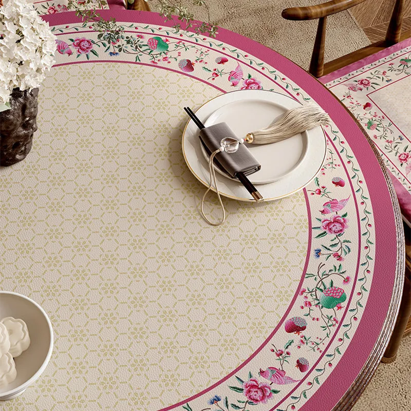 Coral pink round table mat with floral border detail.